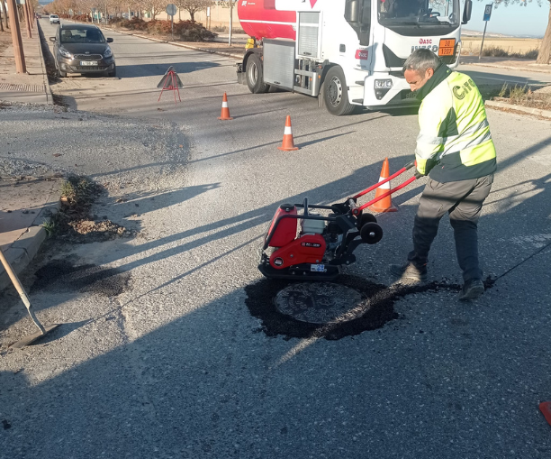 Operario de mantenimiento reparando el firme de un vial del parque